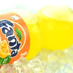 Butelka Fanta Pomarańczowa z sokiem z pomarańczy na lodzie.