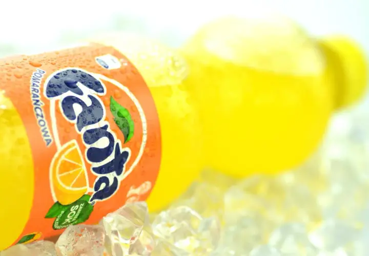 Butelka Fanta Pomarańczowa z sokiem z pomarańczy na lodzie.