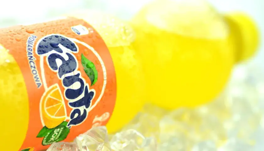 Butelka Fanta Pomarańczowa z sokiem z pomarańczy na lodzie.